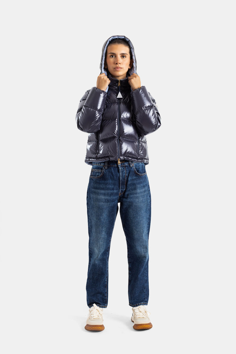 Moncler Niveole Damen-Daunenjacke, frontal getragen, aufgesetzte Kapuze, gerade Jeans, weiße Sneaker im Casual-Chic