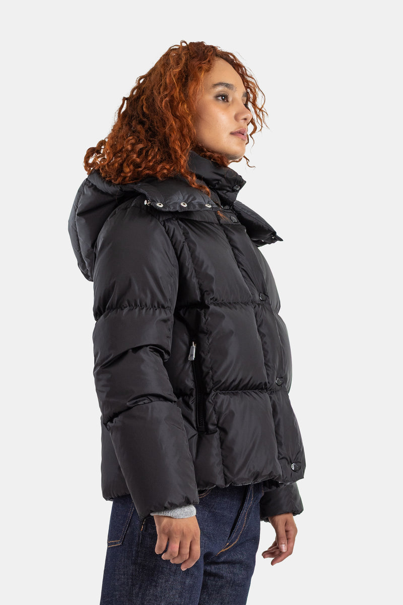 Profilansicht der schwarzen Moncler Castelnew Daunenjacke für Damen mit Kapuze und kurzem, tailliertem Schnitt.