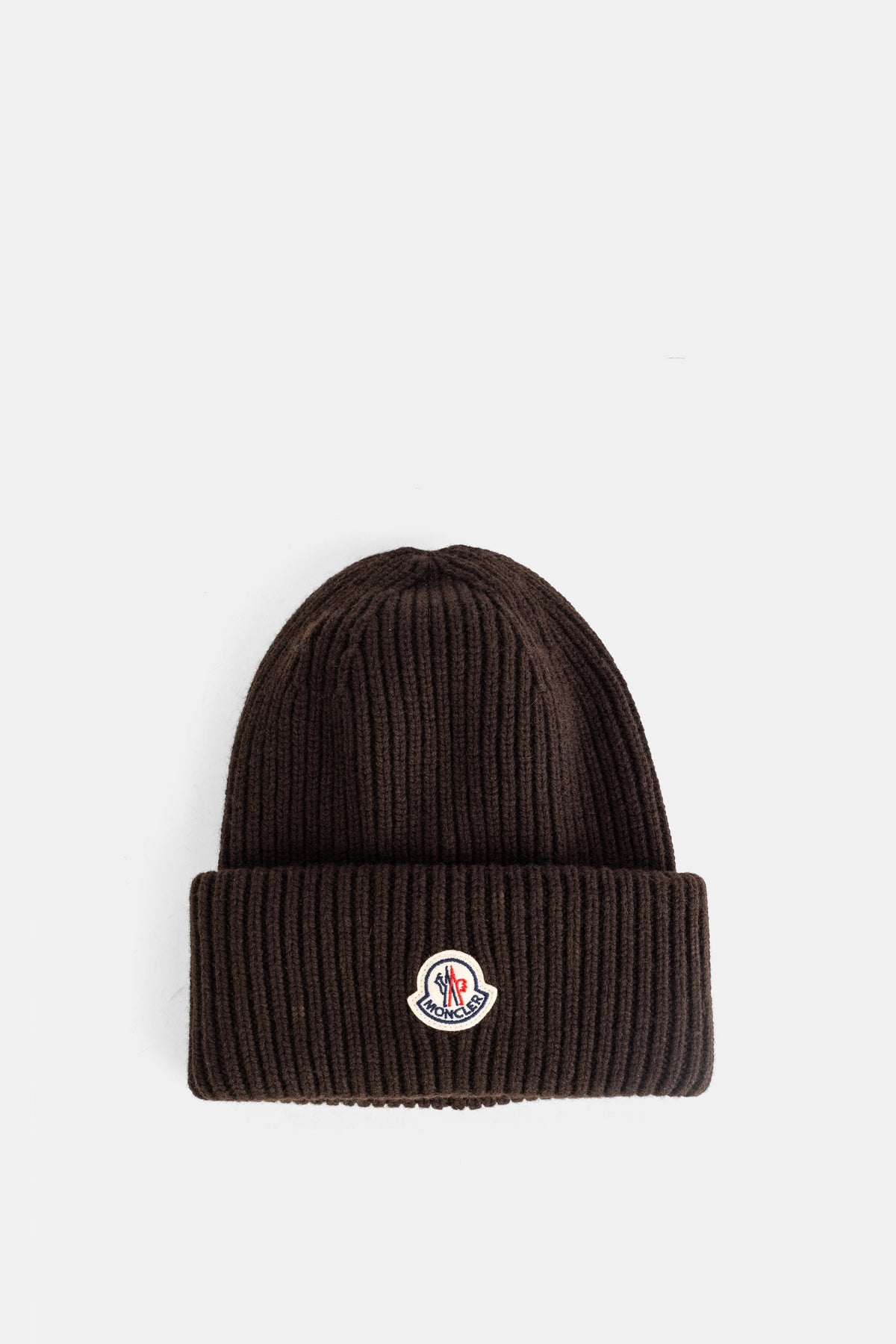 Moncler ribbed beanie in chocolate brown virgin wool, featuring a folded-over cuff and iconic brand logo patch.