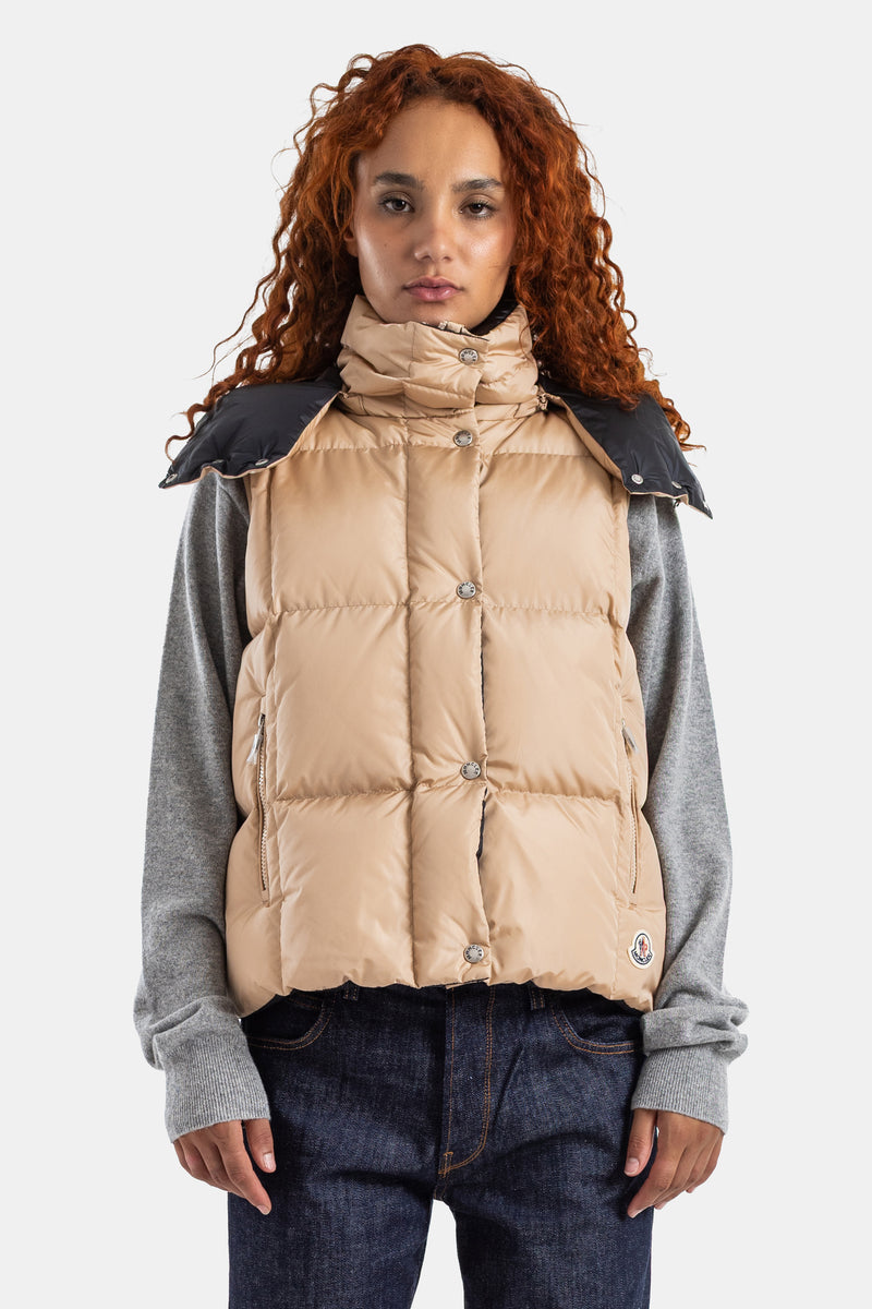 Moncler Macareuxノースリーブダウンベスト。ベージュカラーにブラックのショルダーヨークが映えるスタンドカラーデザイン。トレンド感のあるオーバーサイズでショート丈のシルエットが洗練された印象を与えます。