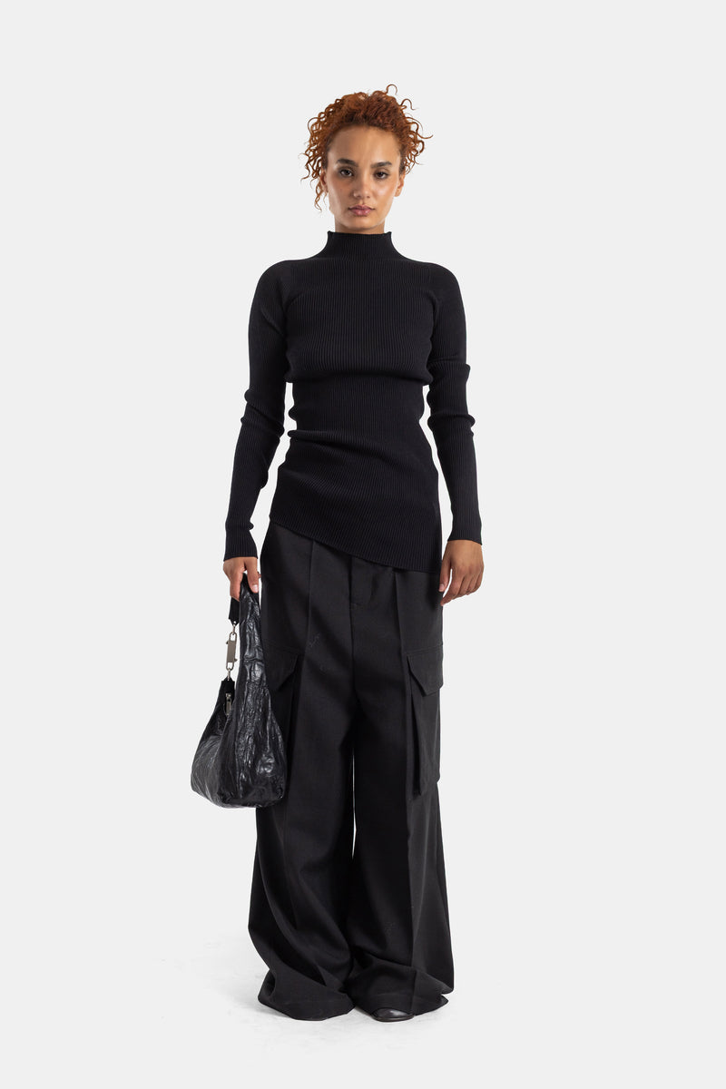 Rick Owens black cargo trousers worn with a ribbed turtleneck sweater and crinkled leather bag, full women's look