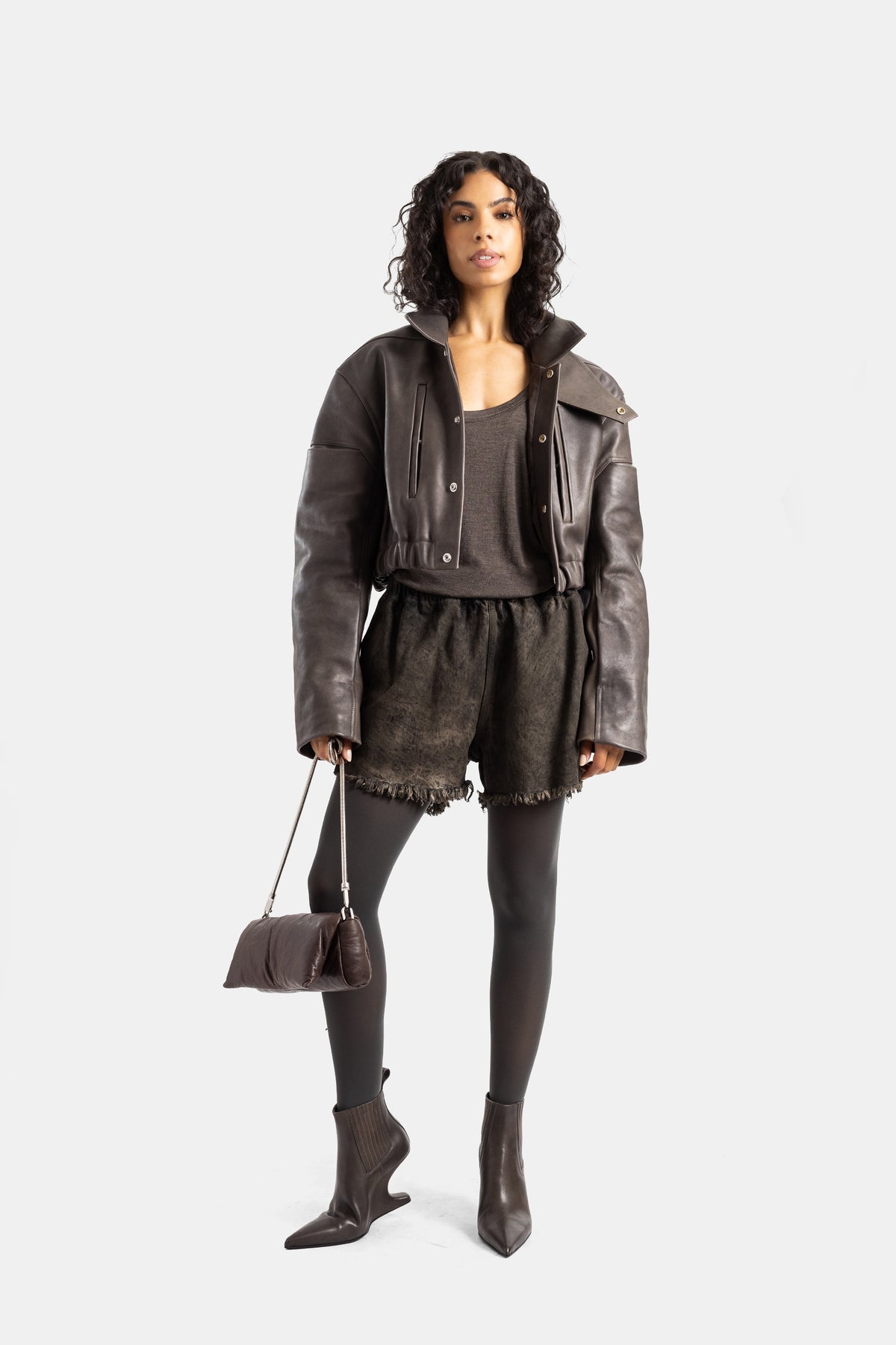 Look completo Rick Owens bomber de cuero marrón mujer con leggings negros botas de punta y bolso bandolera