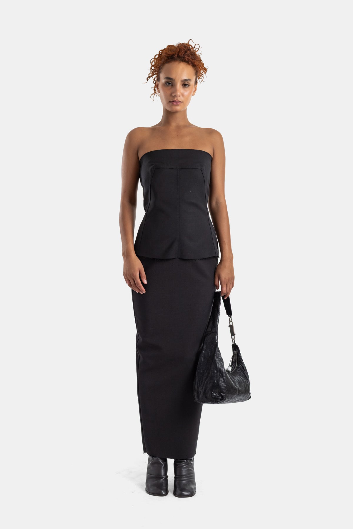 Bustier negro Rick Owens en look total black con bolso hobo de cuero arrugado y botines elegantes para mujer.