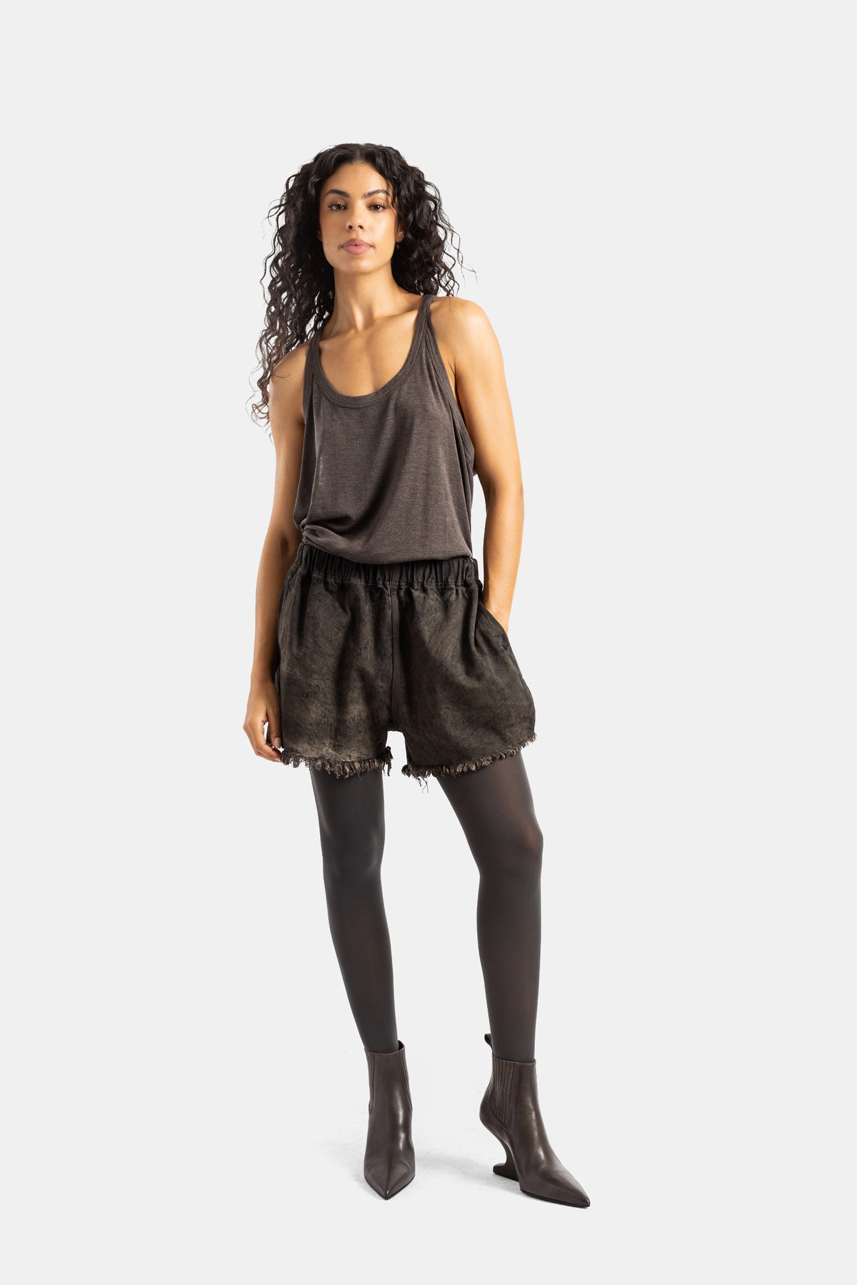 Shorts in denim sfrangiato donna Rick Owens, look marrone monocromo con canotta fluida e leggings abbinati.