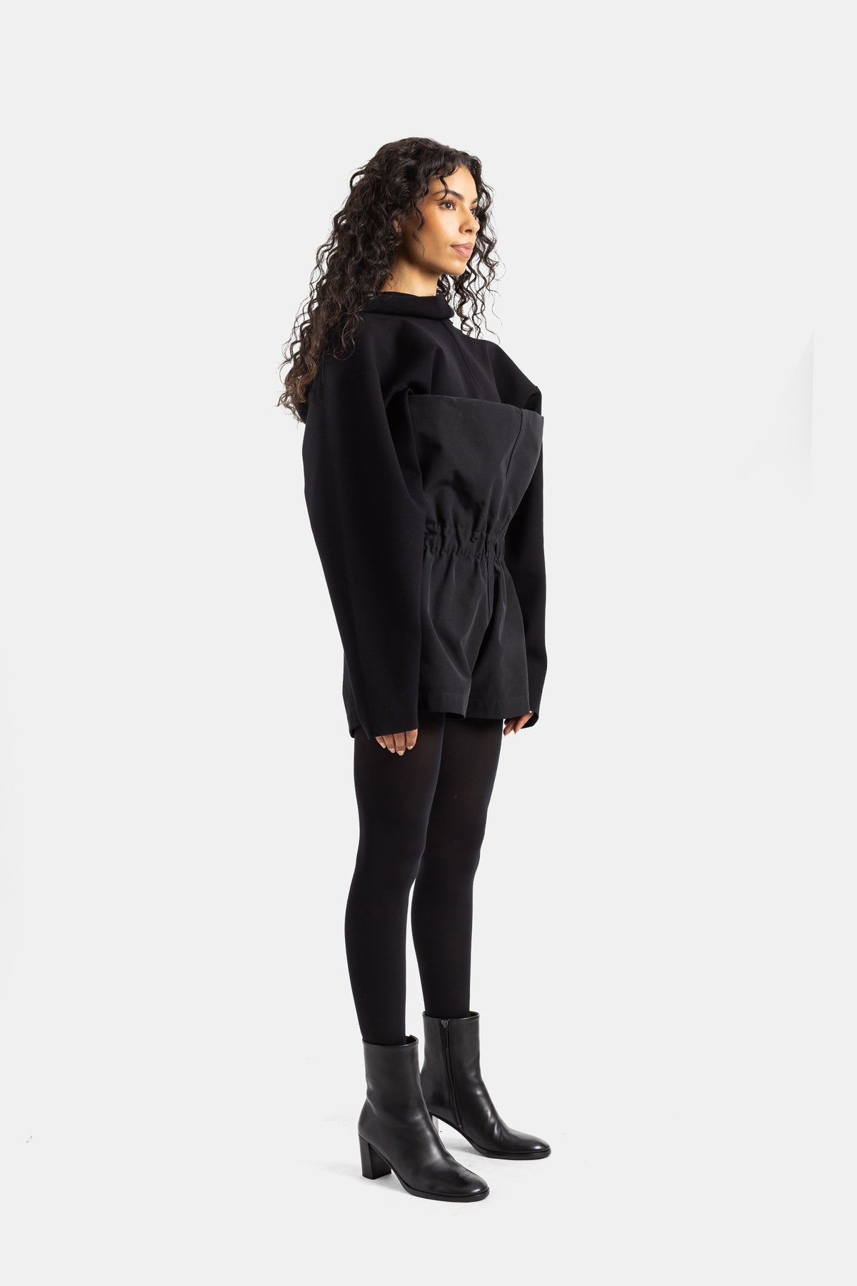 Back view of women's black Rick Owens playsuit, oversized silhouette in soft fabric with gathered belt