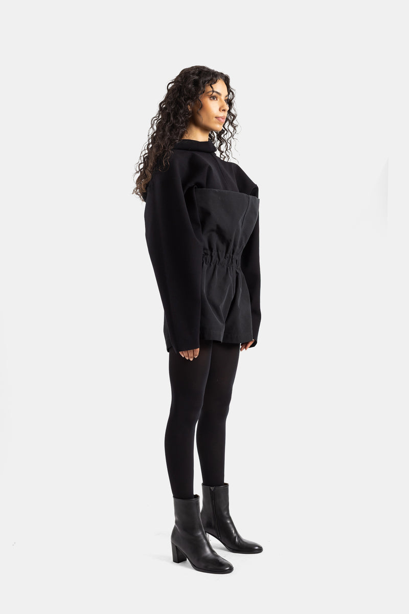 Back view of women's black Rick Owens playsuit, oversized silhouette in soft fabric with gathered belt
