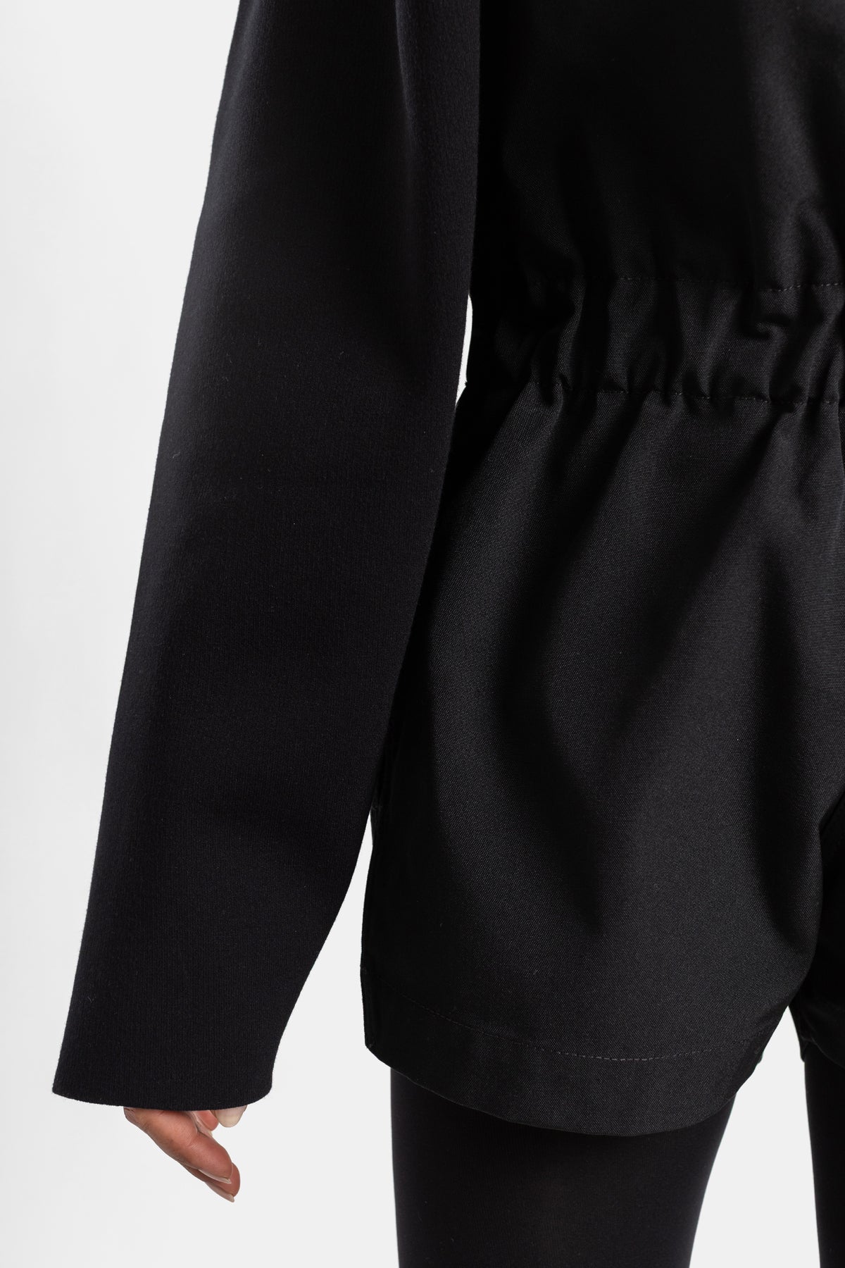 Black Rick Owens playsuit, close-up on oversized long sleeve and gathered waist detail in satin-like fabric