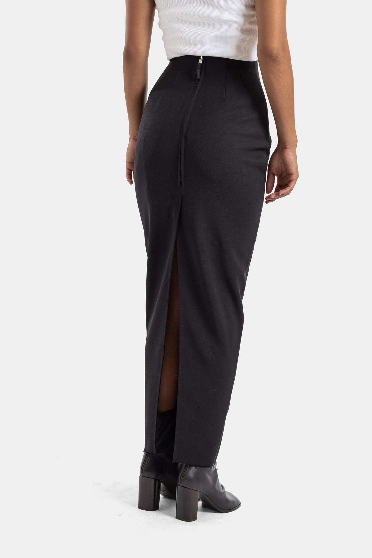 Gonna Pillar nera Rick Owens sul retro con zip centrale e spacco, indossata con stivaletti con tacco a blocco.