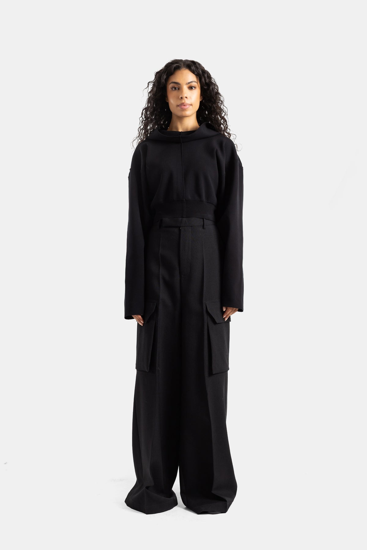 Kurzer schwarzer Rick Owens Damen-Hoodie kombiniert mit weiter Cargo-Hose, monochrome Frontalansicht.