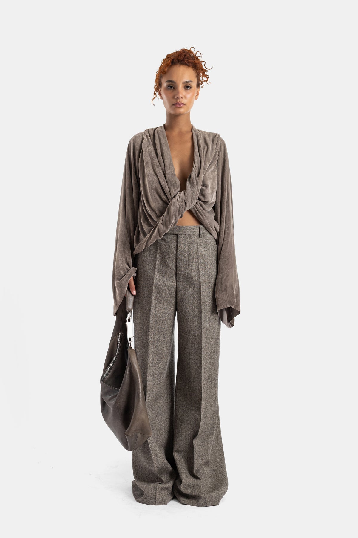 Top Twist de veludo taupe Rick Owens usado com calças largas de lã cinza e carteira de couro oversize.