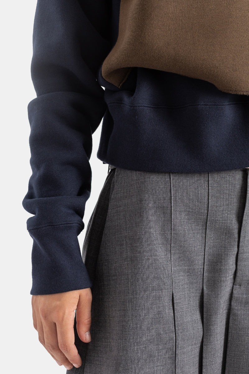 Sacai sweatshirt éponge navy, zoom poignet côtelé et ourlet bord-côte, superposition gilet marron, pantalon gris plissé