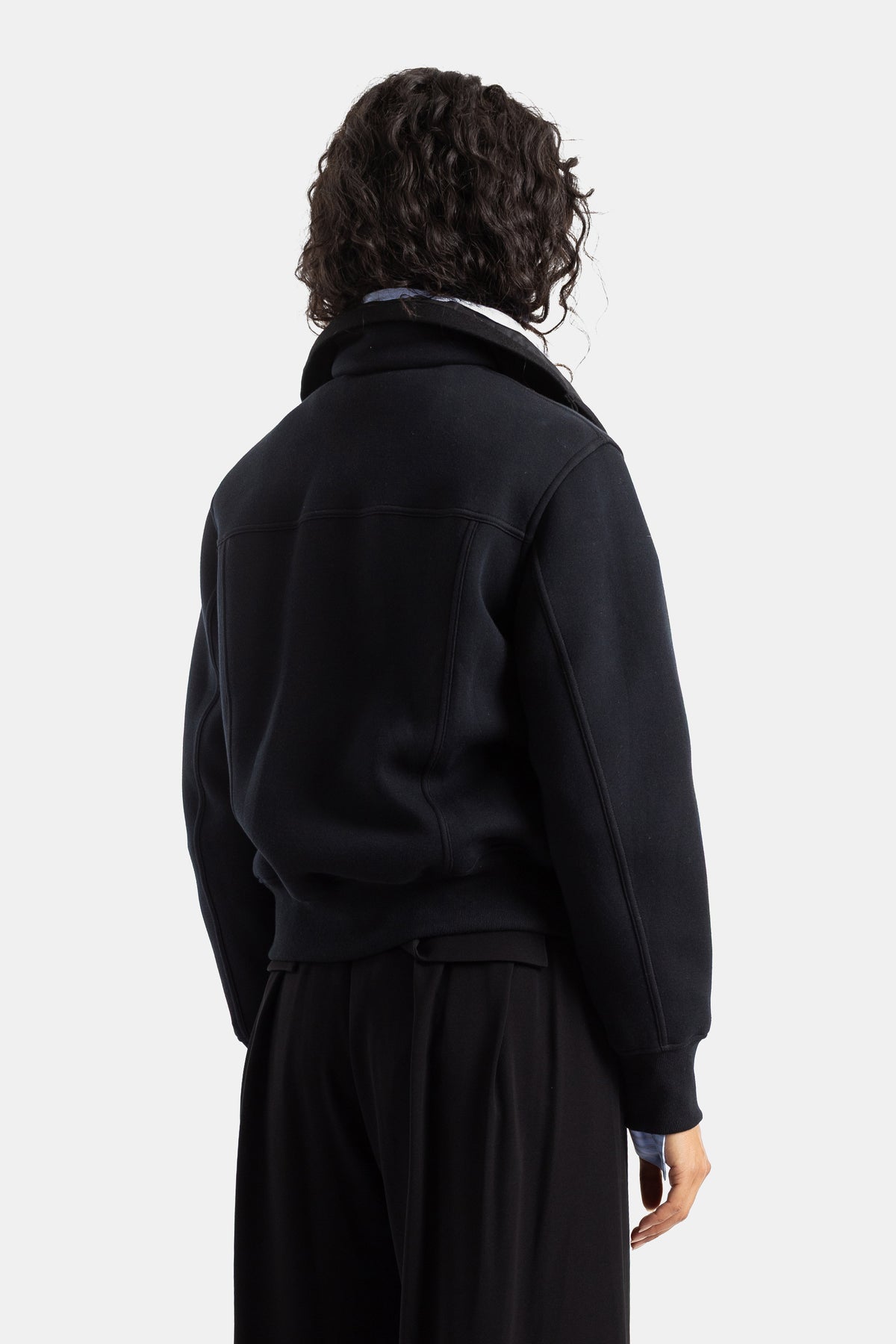Sacai women's black sweat jacket back view showing raglan seam details and bi-material stand-up collar