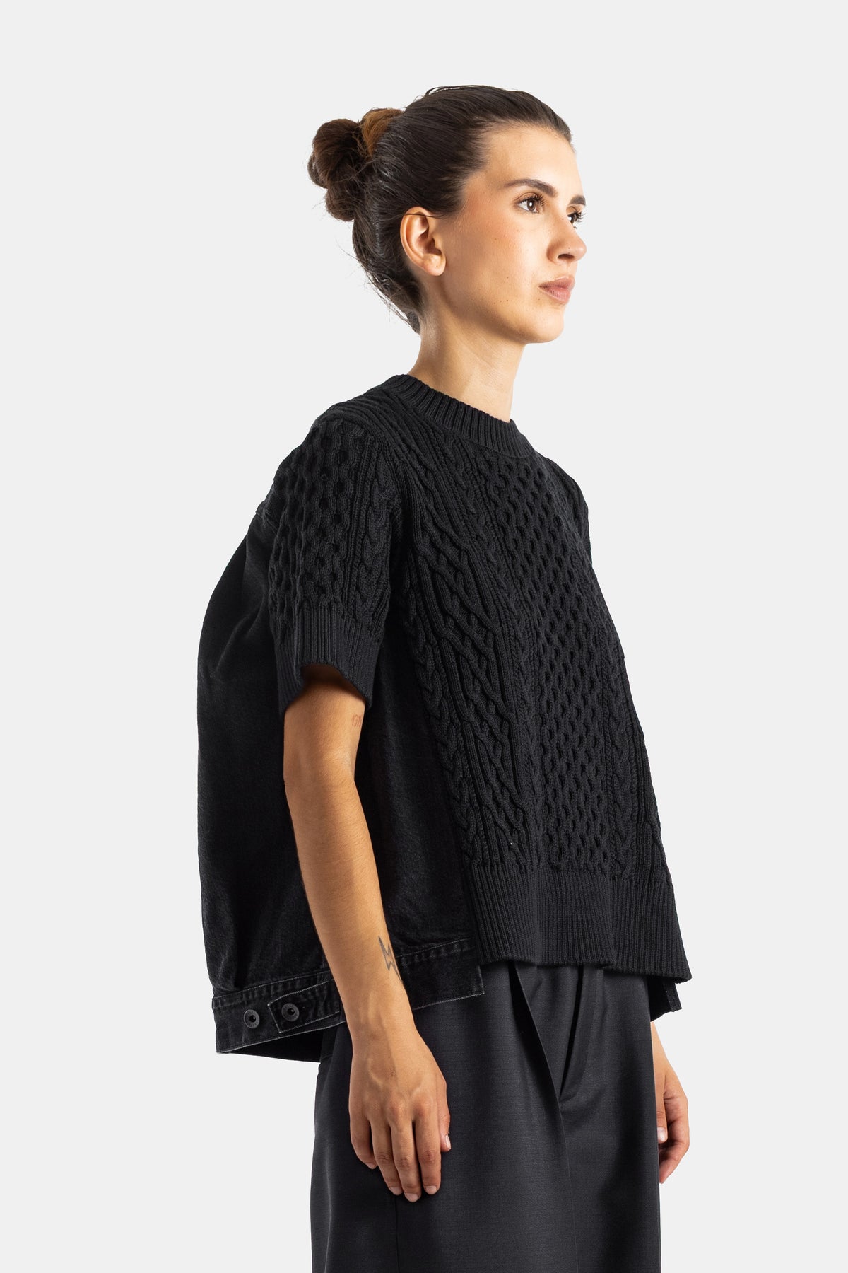 Sacai pull noir vue de profil superposition maille torsadée et denim avec nervures côtelées