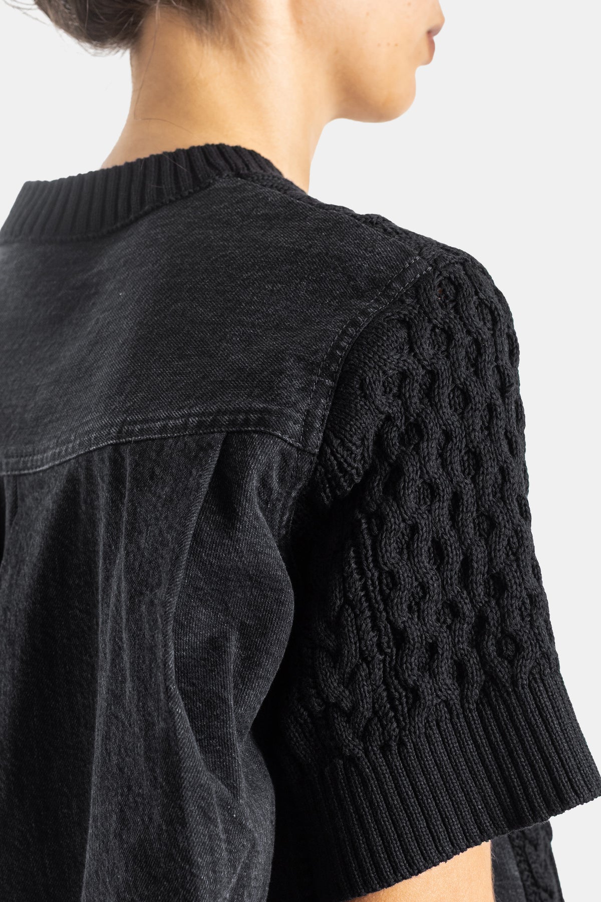 Sacai pull hybride épaule et manche câble-knit noir détail couture denim vue rapprochée femme