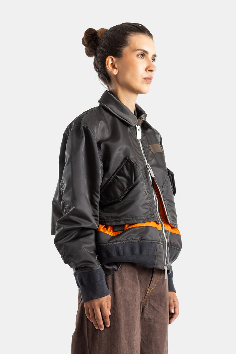 Sacai veste bomber femme profil trois quarts poche poitrine zippée bande orange contrastante bas kaki