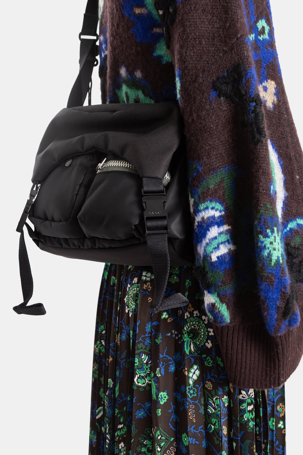 Sacai blouson jacquard fleuri, focus sur sac nylon noir bandoulière porté épaule, jupe plissée florale