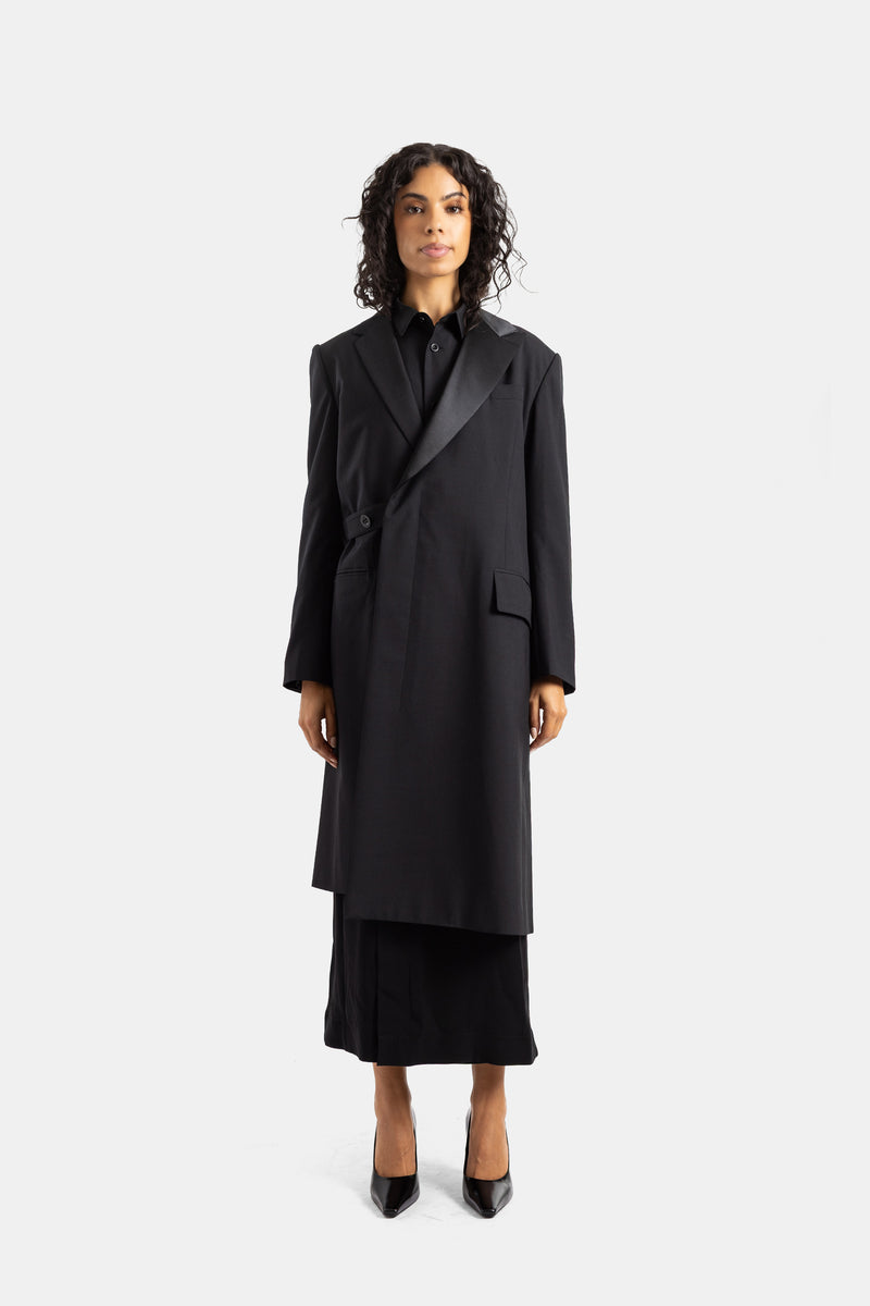 Sacai long black asymmetric suiting coat featuring elegant satin lapels and a structured oversize silhouette