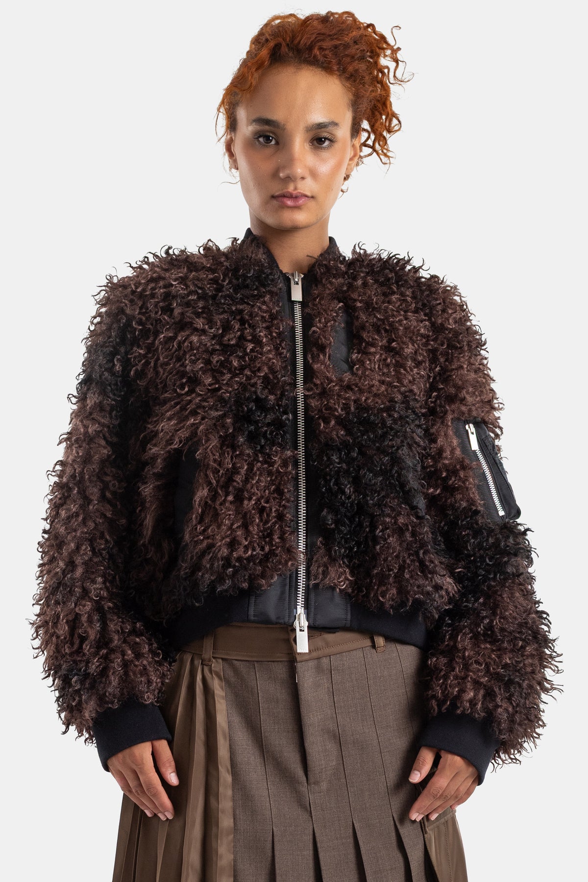 Blusão bomber oversize Sacai em pelo sintético encaracolado castanho-chocolate com fecho de correr prateado.