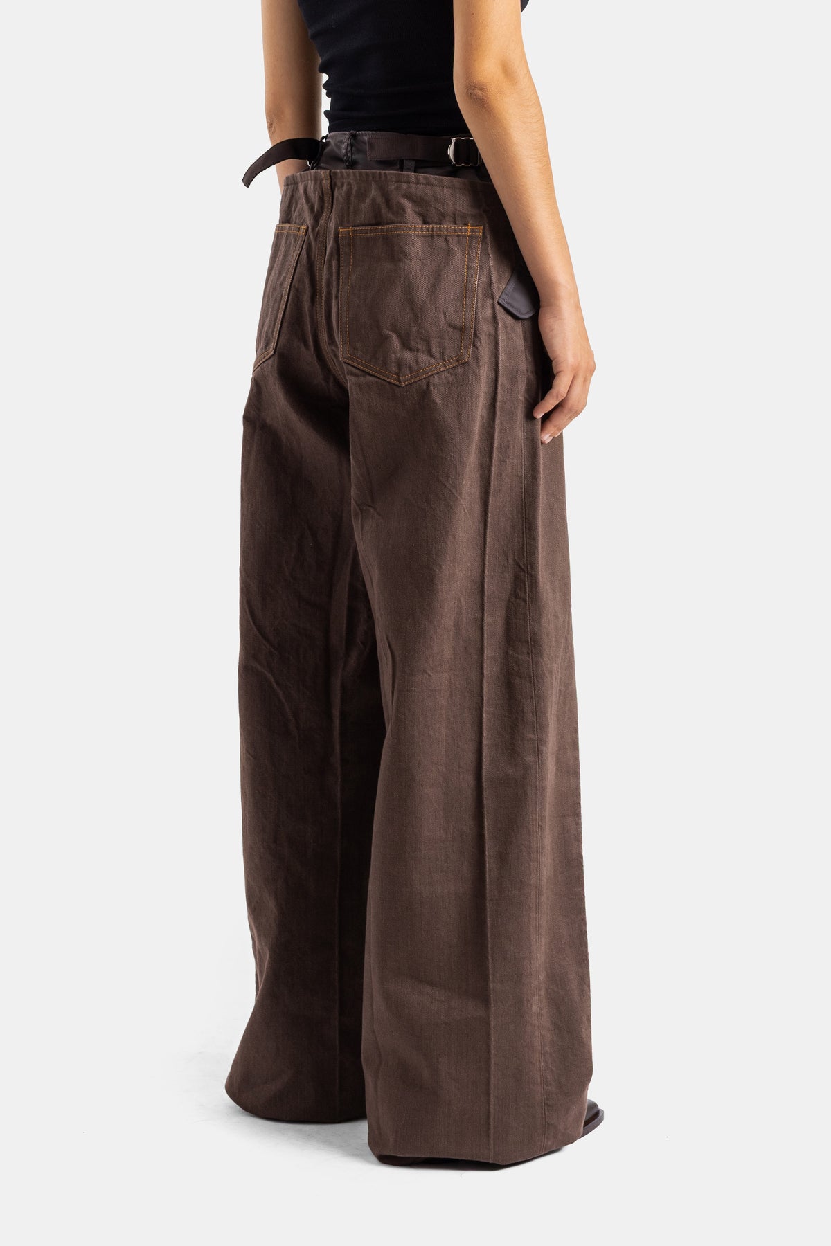 Sacai pantalon hybride denim marron dos vue trois quarts jambe ultra large ceinture noire surpiqûres contrastantes