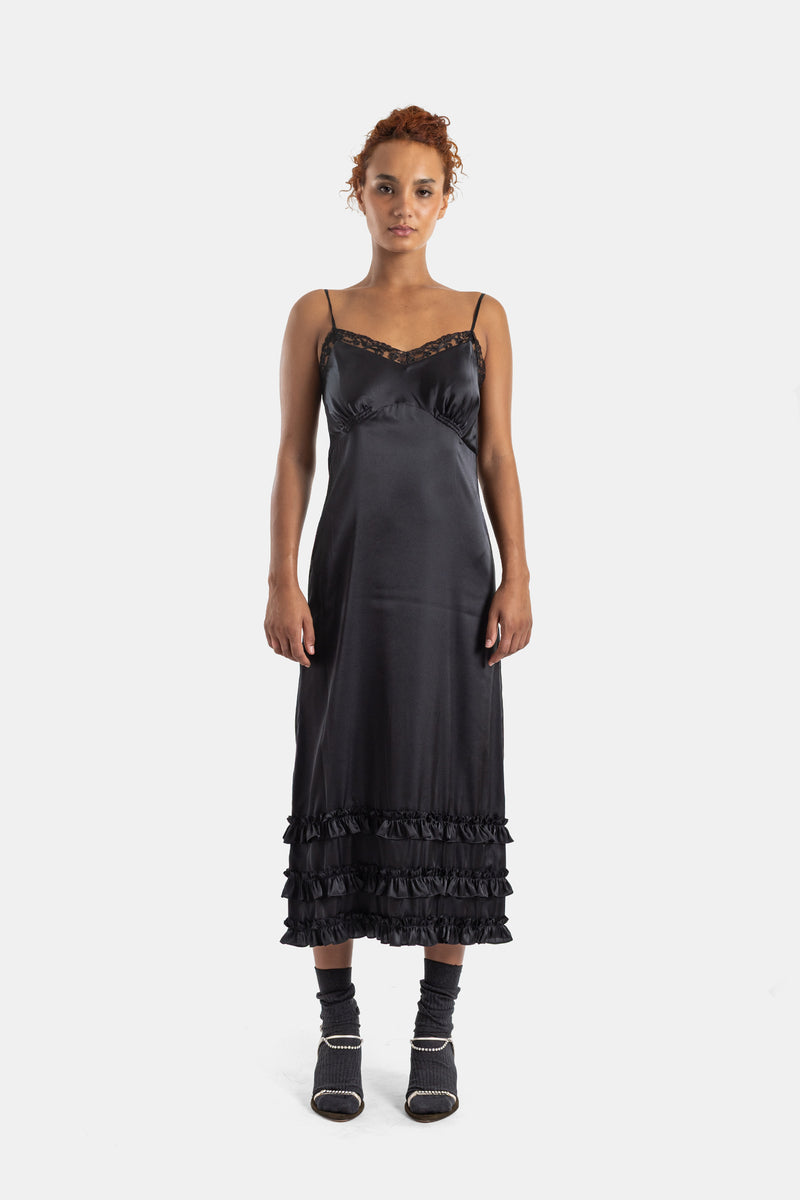 Vestido lencero Simone Rocha de raso negro con escote corazón de encaje, volantes y corte midi femenino.