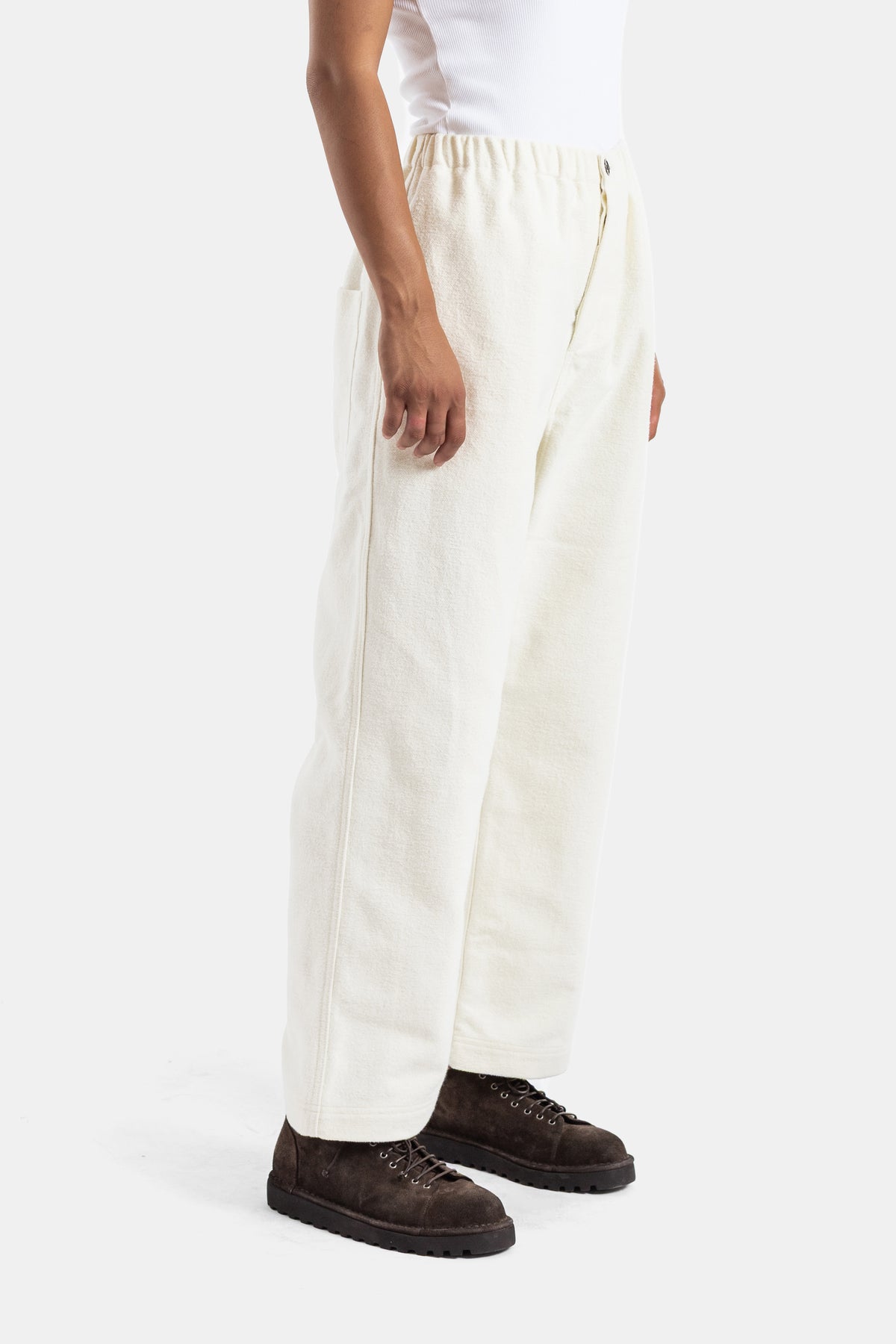 Pantalón de lana Sofie d'Hoore con cintura elástica, silueta recta ecru, vista lateral con botas de ante marrón