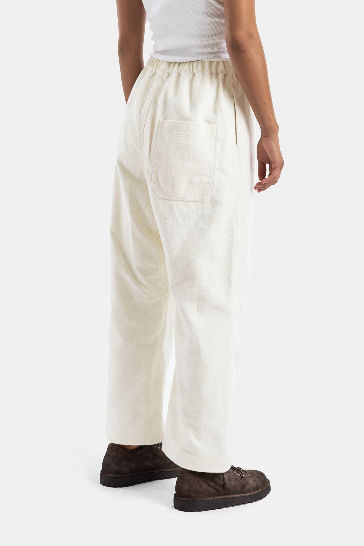 Pantalón de lana ecru Sofie d'Hoore, vista trasera, bolsillo de parche, cintura elástica y zapatos de ante marrón oscuro