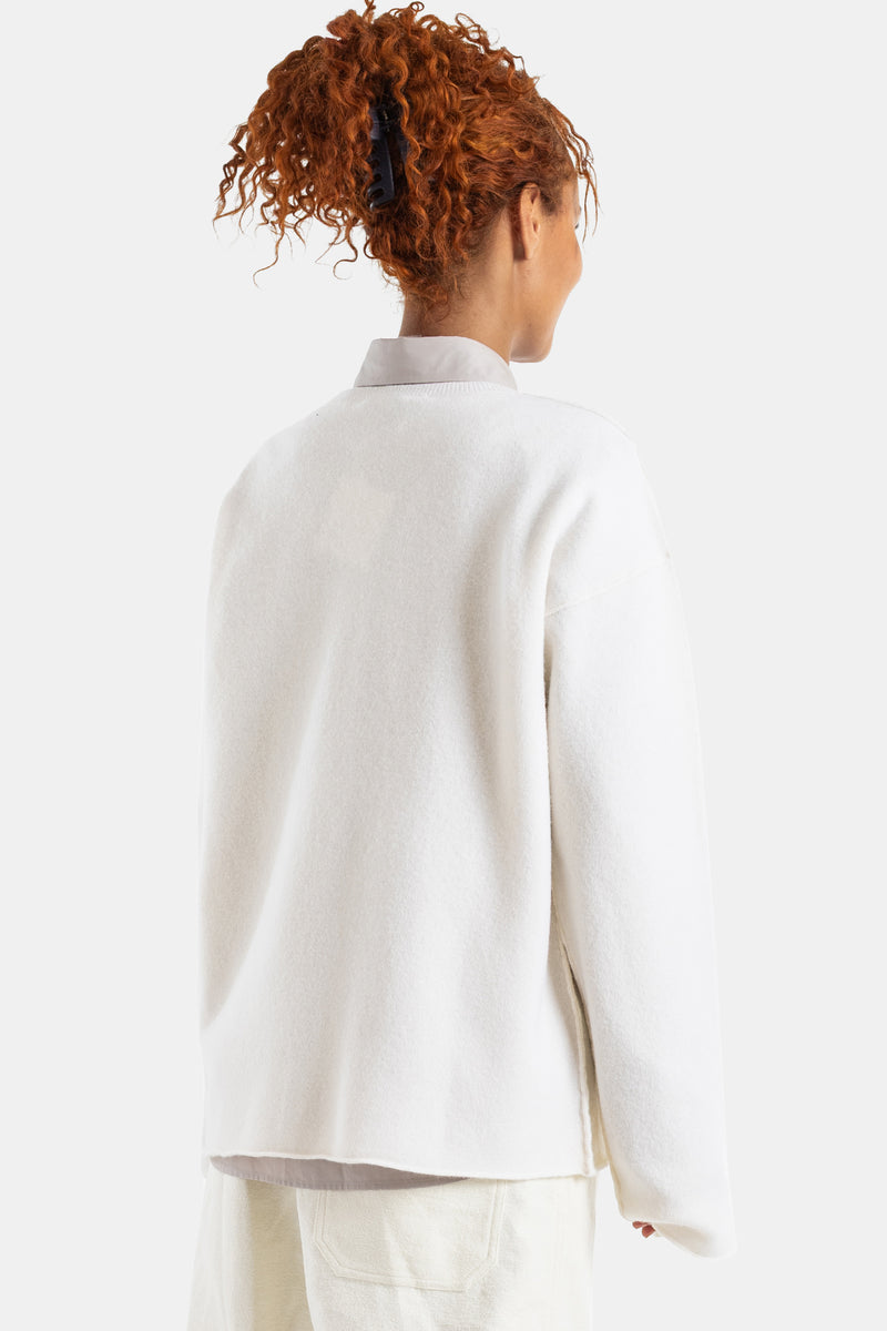 Sofie d'Hoore white wool sweater seen from behind, loose crewneck fit, model with red hair tied up in a bun