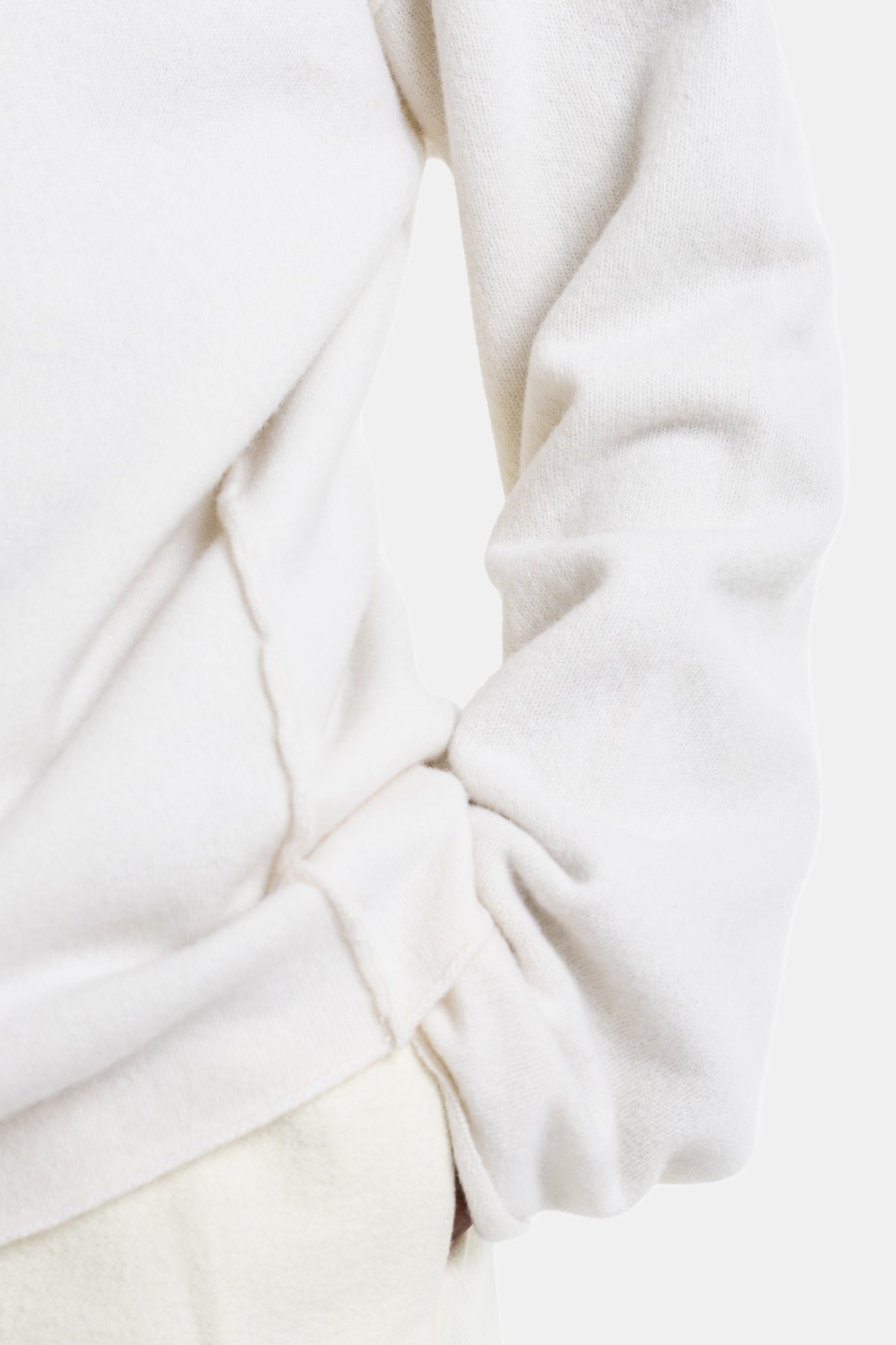 Sofie d'Hoore white wool sweater detailed bottom with a twisted knot, textured fabric and oversized seams