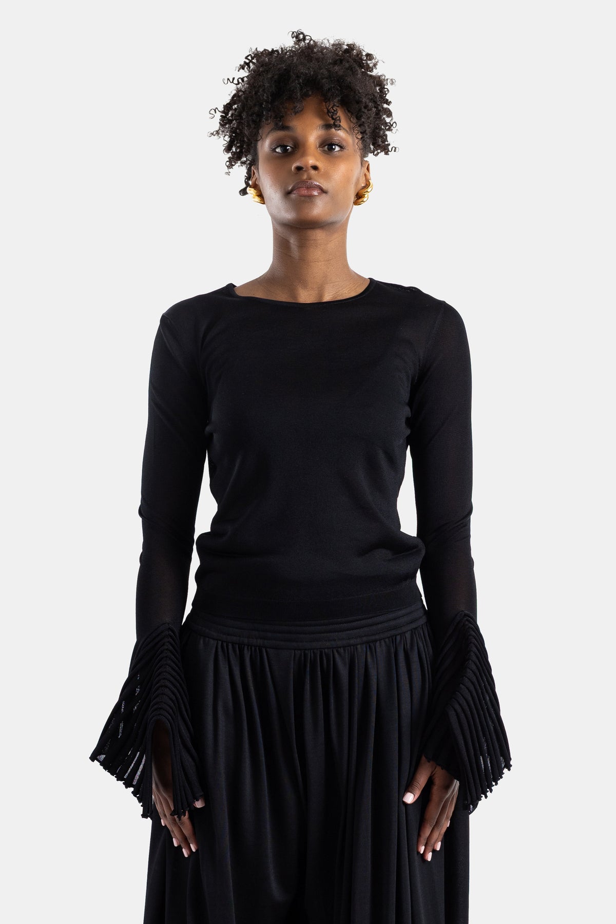 Maison Alaïa haut manches longues noir évasées franges plissées jersey stretch coupe ajustée silhouette minimaliste SS26