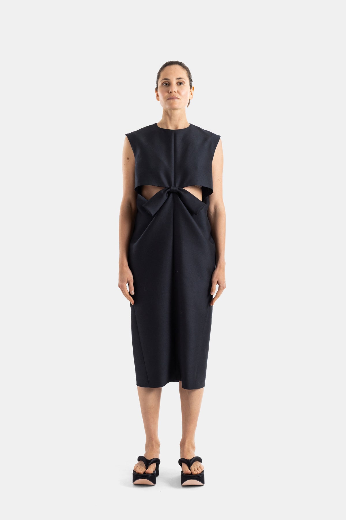 Balenciaga schwarzes ärmelloses Kokonkleid architektonische Schleife Taillenausschnitte strukturierte Midi-Silhouette SS26