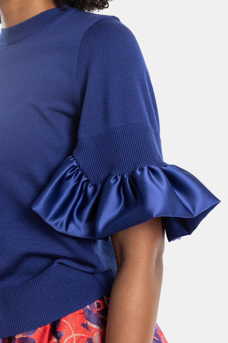 Blue knit top with satin ruffles
