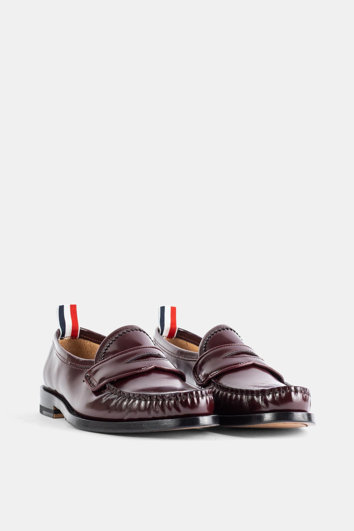 Thom Browne paire mocassins varsity cuir brillant bordeaux languette rayée rouge blanc marine vue trois quarts
