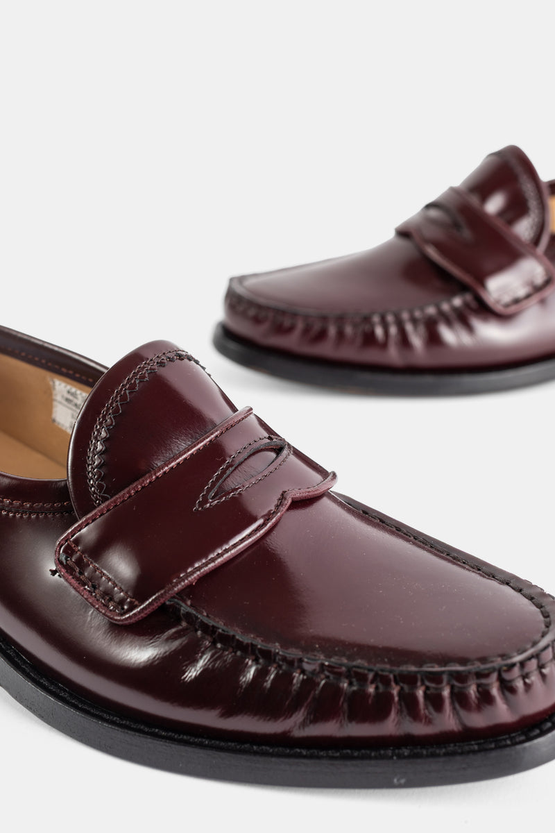 Thom Browne mocassins penny varsity gros plan coutures moccasin plissées cuir verni bordeaux brillant