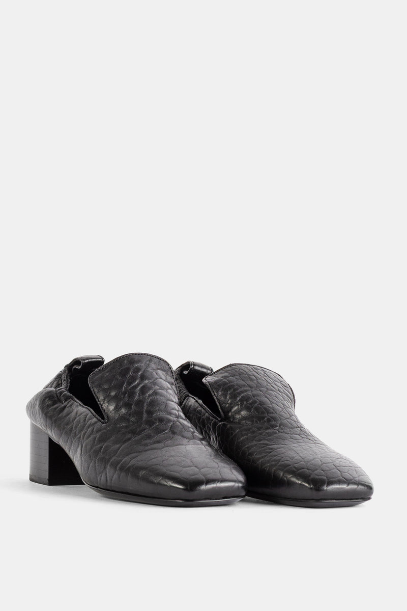 Studio Nicholson Moon Loafer in Schwarz aus geprägtem Leder mit flachem Blockabsatz in der Frontansicht.