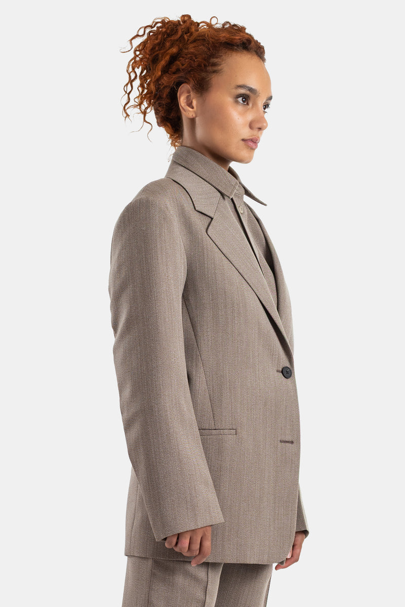 Studio Nicholson Damen-Blazer in Taupe Meliert von der Seite, mit einem Knopf und Oversize-Silhouette.